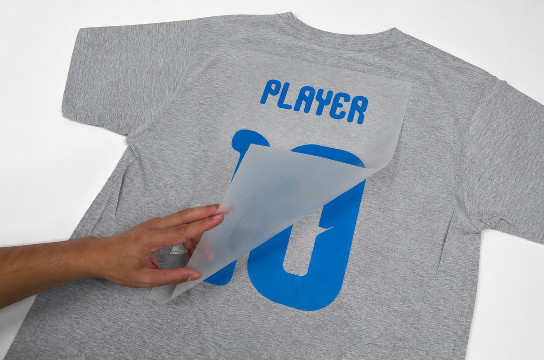 Peeling the backing sheet off the transfer to reveal the design
